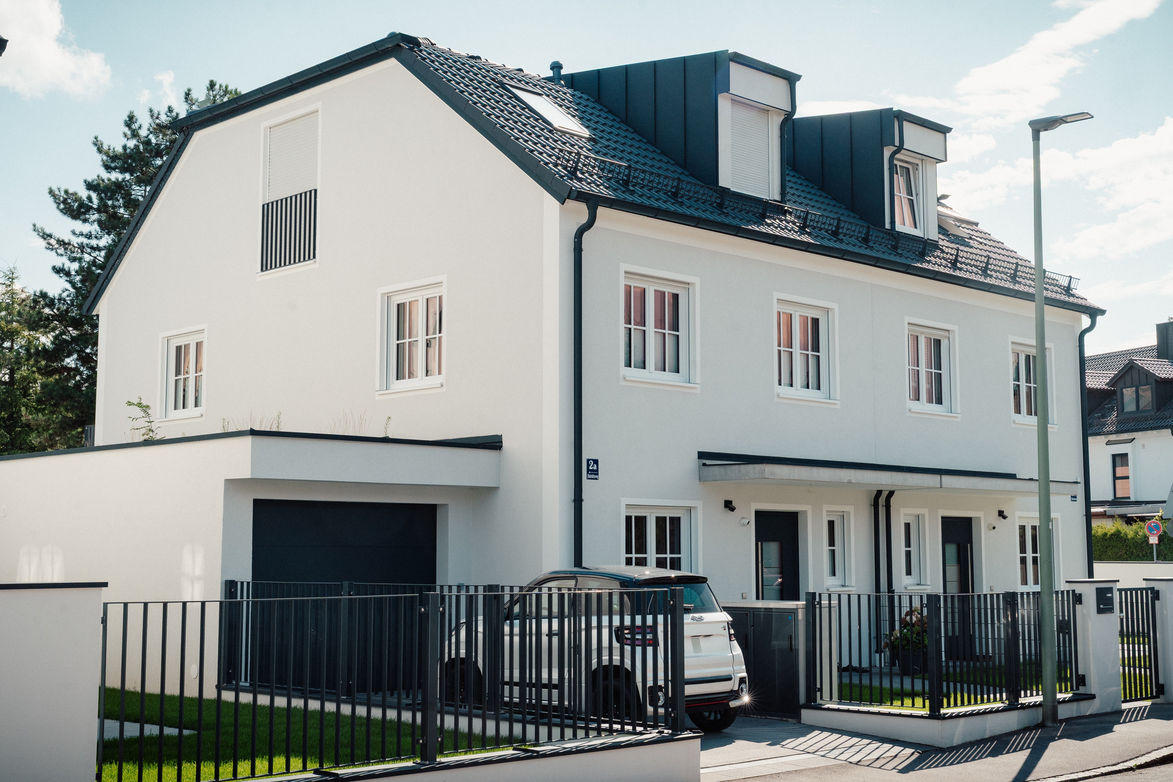 Hoferichterweg 2, 2a & 2b – Stadthaus mit heller Fassade, Dachgauben, Garage und Vorgartenzaun (Straßenansicht)